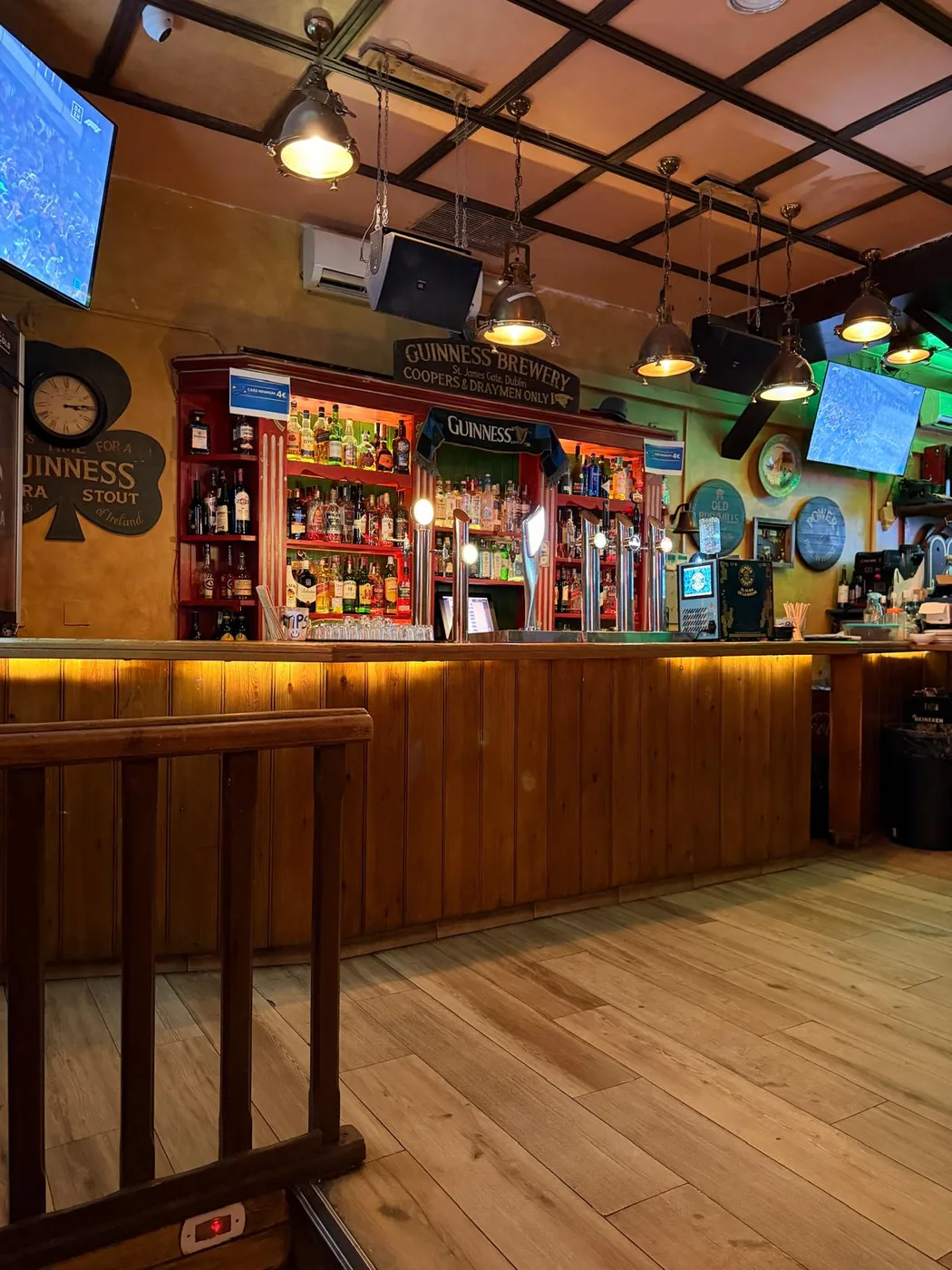 Barra del pub irlandés O'Connell St cerca de Sol — madera, taburetes y luz cálida